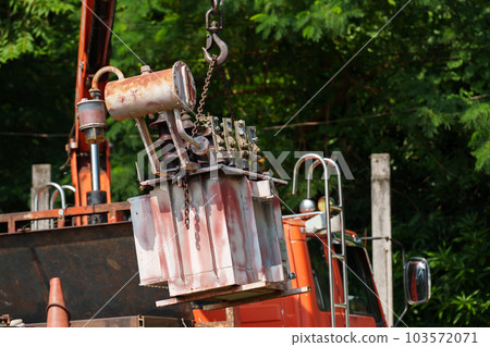 crane hook lifts up old distribution transformer 103572071