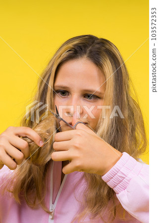 Cheerful kid cut long hair, casual fashion style for beautiful child, girl use hairdresser scissors. 103572353