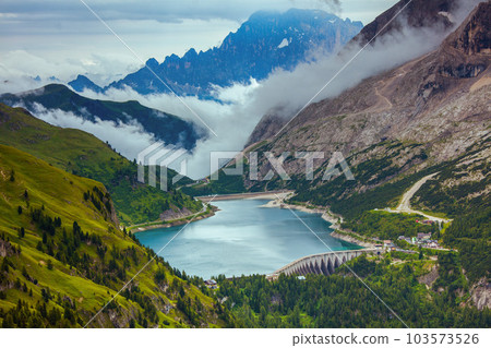 landscape with mountains, hills, Fedaia lake, trees and fog 103573526