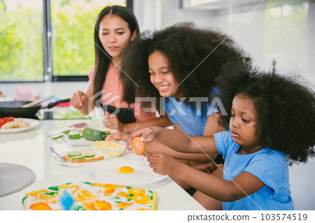 Children playing learning practise cooking food with mother at home kitchen happy funny holiday activity 103574519