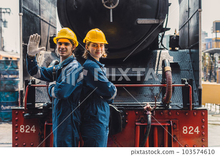 Train engineer team working service maintenance old dirty vintage classic steam engine locomotive in train repair workshop at train station. Train engineer team working service maintenance old dirty vintage classic steam engine locomotive in train repair workshop at train station. 103574610