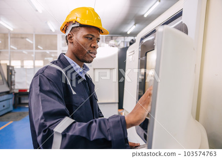 Black male engineer technician staff worker enjoy working operate control modern lathe CNC machine in metal factory Black male engineer technician staff worker enjoy working operate control modern lathe CNC machine in metal factory 103574763