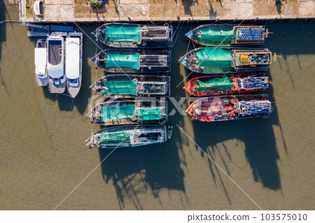 Aerial view of fishing boats moored at marina 103575010