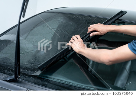 Rolling car window film on front windscreen glass surface 103575040