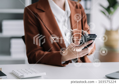 Zero trust security concept Person using smartphone and tablet with zero trust icon on virtual screen of Data businesses.in office. Zero trust security concept Person using smartphone and tablet with zero trust icon on virtual screen of Data businesses.in office. 103575224