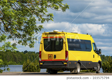 Back view of a yellow school bus standing on the parking lot Back view of a yellow school bus standing on the parking lot 103575794