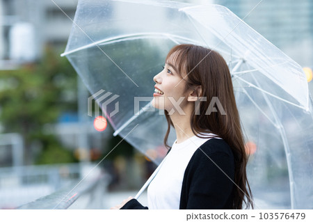 A woman going home on a rainy day 103576479