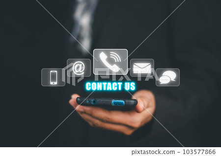 Contact us or Customer support hotline people connect, Person hand using smart phone with Contact us icon on VR screen on office desk, email, address, live chat, internet wifi. Contact us or Customer support hotline people connect, Person hand using smart phone with Contact us icon on VR screen on office desk, email, address, live chat, internet wifi. 103577866