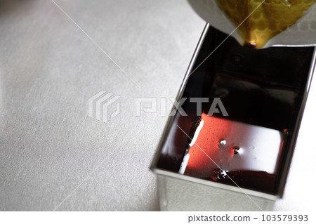Pour the pudding caramel sauce into the mold Pour the pudding caramel sauce into the mold 103579393