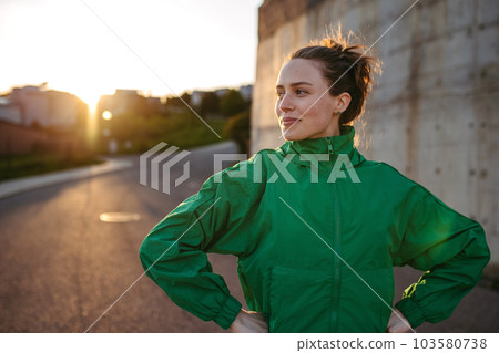 Young woman in sportive clothes resting outdoor. 103580738