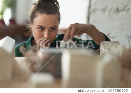 Young female architect hard working on design of new house, building. Young female architect hard working on design of new house, building. 103580895