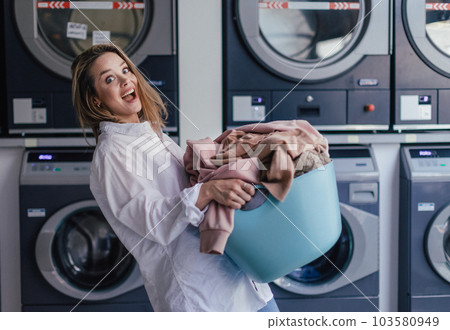 Young woman waiting in a laundry room. Young woman waiting in a laundry room. 103580949