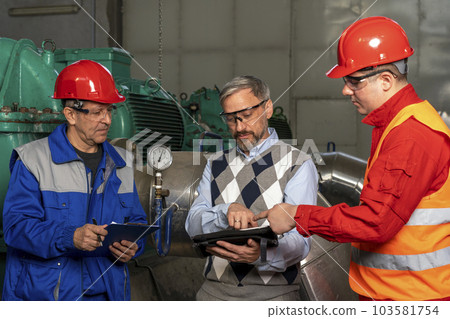 Technical Manager Using Digital Tablet and Discussing About Production Process with Two Power Plant Workers Technical Manager Using Digital Tablet and Discussing About Production Process with Two Power Plant Workers 103581754