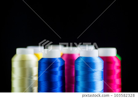 set of different color sewing threads,on black background. 103582328
