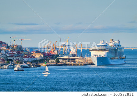 View of Lisbon over Tagus river from Almada with yachts tourist boats and cruise liner moored at cruise terminal at sunset. Lisbon, Portugal 103582931