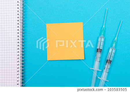 Vaccination or Revaccination Concept - Two Medical Syringe on Blue Table Vaccination or Revaccination Concept - Two Medical Syringe on Blue Table 103583505