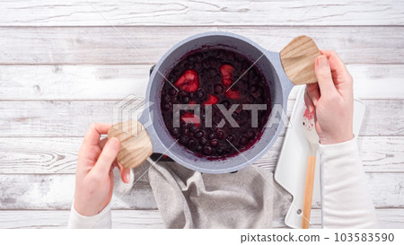 Step by step. Preparing mixed berry compote from frozen berries in a nonstick cooking pot. 103583590
