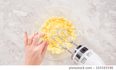 Flat lay. Step by step. Mixing ingredients in a glass mixing bowl to bake funfettti bundt cake. 103583596