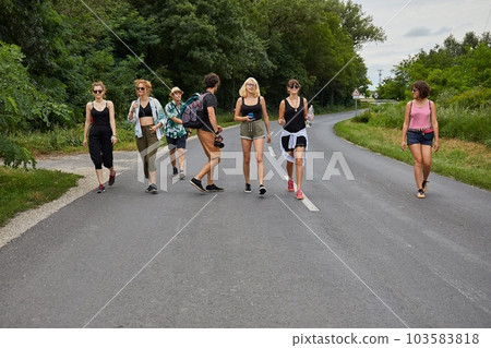 Young group of friends walking by the road Young group of friends walking by the road 103583818
