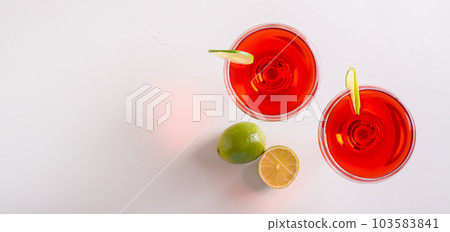 Alcoholic cosmopolitan cocktail in glasses and lime on the table top view web banner Alcoholic cosmopolitan cocktail in glasses and lime on the table top view web banner 103583841