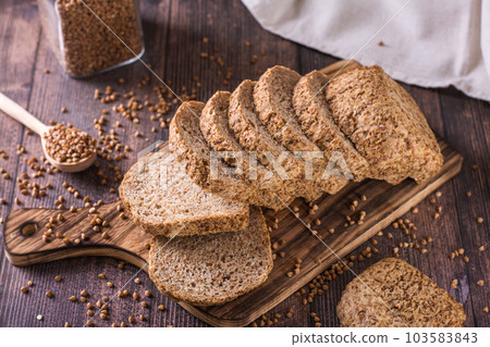 Pieces of homemade buckwheat bread on a cutting board on the table Pieces of homemade buckwheat bread on a cutting board on the table 103583843
