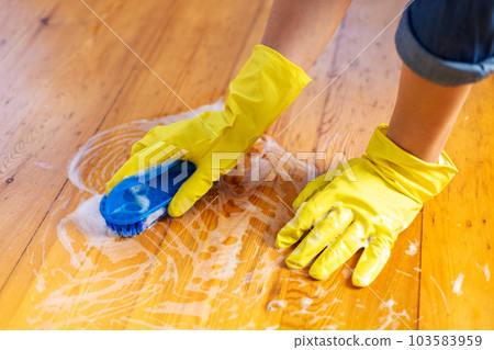 Woman in rubber gloves is using floor brush to cleaning floor Woman in rubber gloves is using floor brush to cleaning floor 103583959