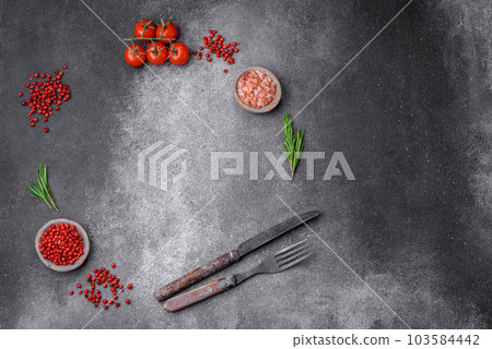 Ingredients, spices, salt, tomatoes, rosemary and cutlery knife and fork 103584442