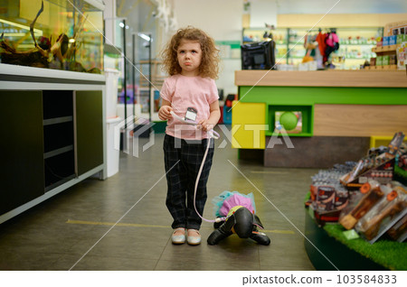 Little girl child at pet shop with toy dog 103584833