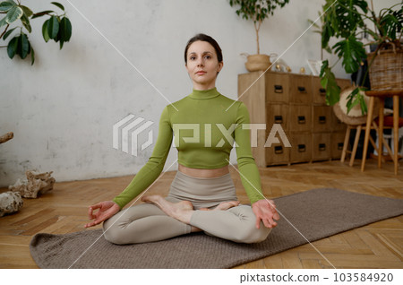 Healthy woman practicing meditation and relaxation yoga exercise indoors 103584920
