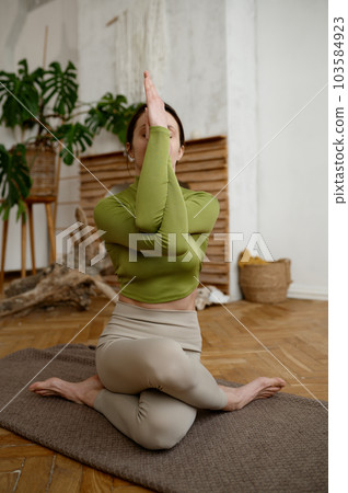 Portrait of attractive athlete woman practicing gomukhasana cow yoga pose 103584923