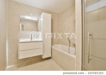 a bathroom with a sink and bathtub next to the tub, in front of a mirror on the wall 103585163