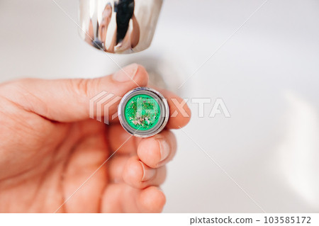 A plumber cleans a water purification filter in faucet faucets in a washbasin 103585172