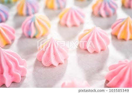 Freshly baked unicorn meringue cookies on a baking sheet with a parchment paper. 103585349
