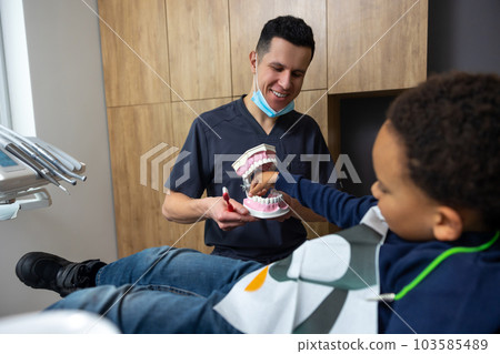 Dark-skinned boy interested in jaw mock-up 103585489