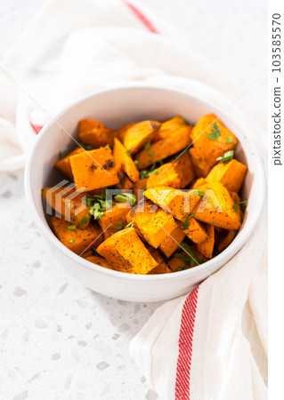 Serving oven-roasted sweet potatoes in a white ceramic bowl. Serving oven-roasted sweet potatoes in a white ceramic bowl. 103585570