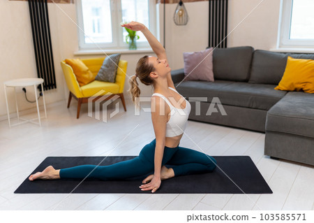 Young fit woman in sportswear practicing yoga on exercise mat. Young fit woman in sportswear practicing yoga on exercise mat. 103585571