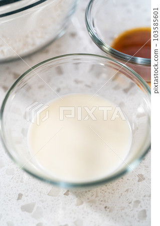 Measured ingredients in glass mixing bowls to make the vanilla glaze for bundt cake. 103585601