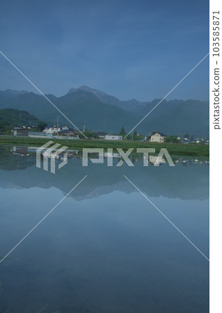 北斗市白州町的晴霧。反映在稻田水面上的山脈和城市景觀 103585871