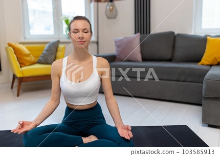 Athletic woman in sportswear practicing yoga and meditating 103585913