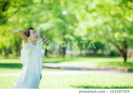 A woman stretching in a fresh green park A woman stretching in a fresh green park 103587505