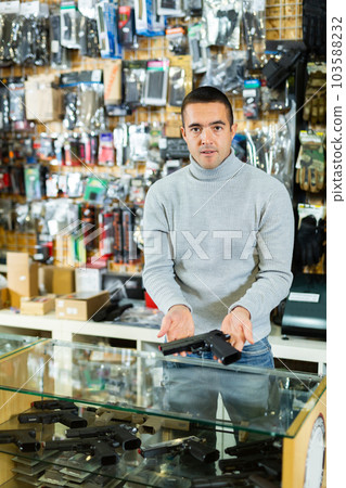 Seller man at counter in weapon shop 103588232