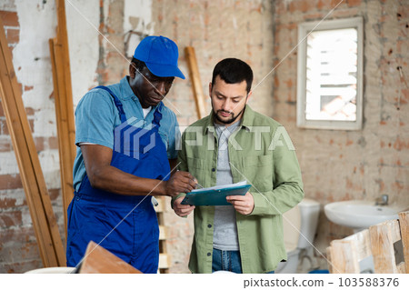 Two men talking on indoor construction site Two men talking on indoor construction site 103588376