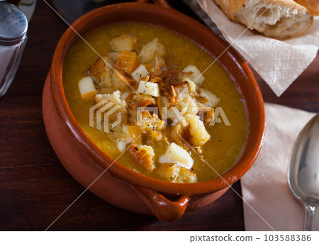 Vegetable soup with croutons and cheese in a clay plate 103588386