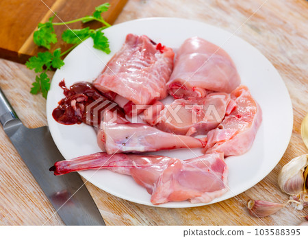 Chopped rabbit with garlic and spices on white plate with knife 103588395