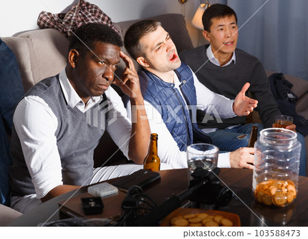 Upset males emotionally watching tv Upset males emotionally watching tv 103588473