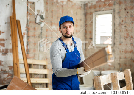 Man carrying wooden materials at construction site 103588514