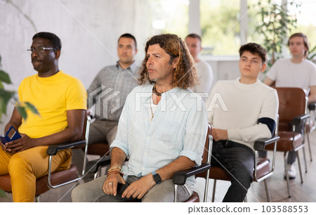 Group of men listening to lecture in auditorium attentively Group of men listening to lecture in auditorium attentively 103588553