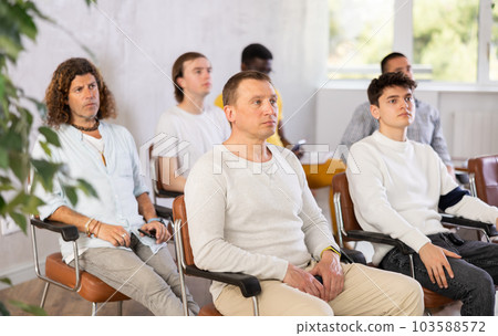 Adult male student listening to lecture with group of men Adult male student listening to lecture with group of men 103588572