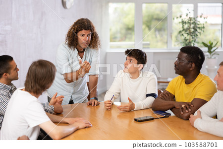 Group of men discussing something at the desk Group of men discussing something at the desk 103588701