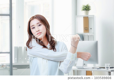 Female employee stretching in the office Female employee stretching in the office 103589808